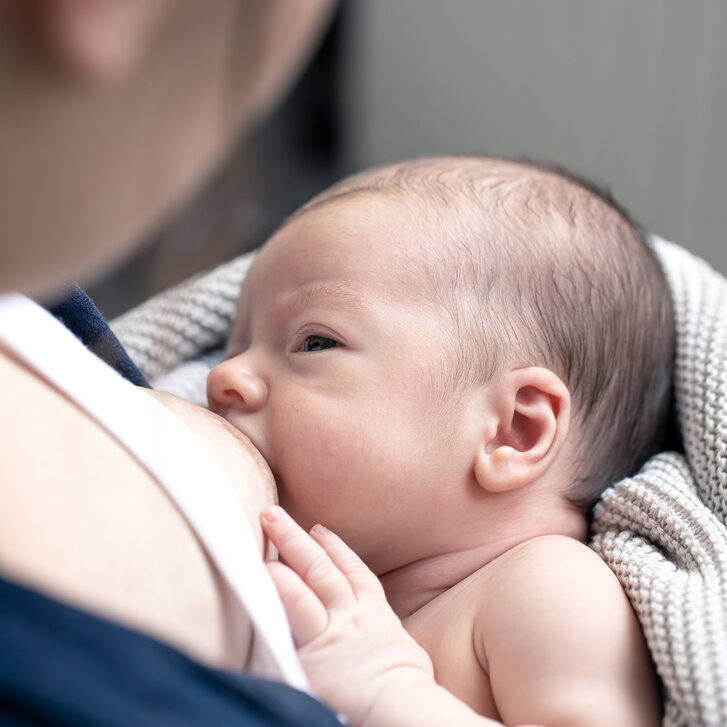 Mama stillt ihr Neugeborenes Mama stillt ihr Neugeborenes